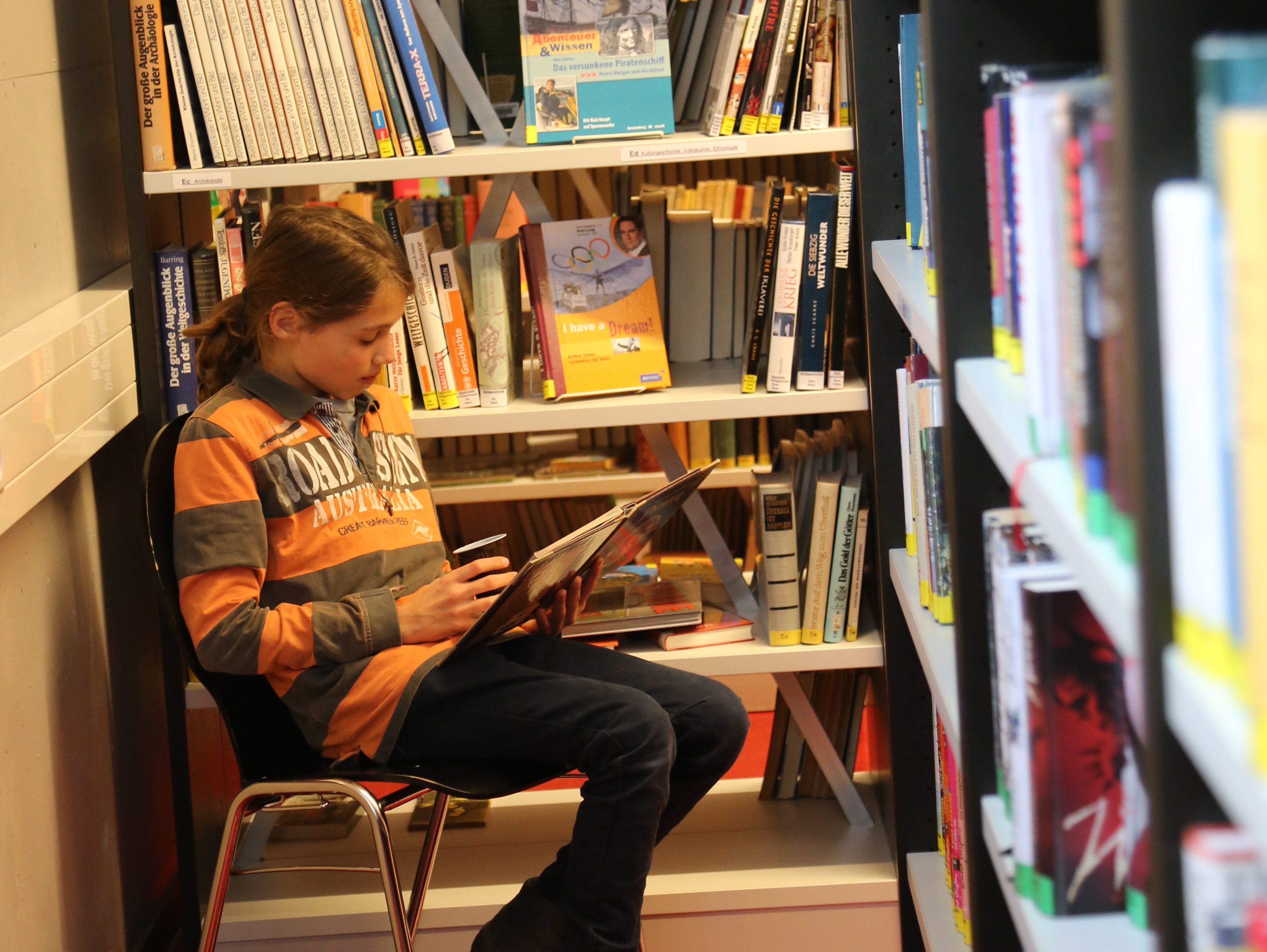 Schüler liest in der Bibliothek